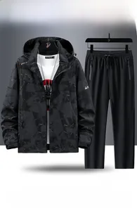 Detailed view of men's hooded camouflage jacket and black outdoor sports trousers set