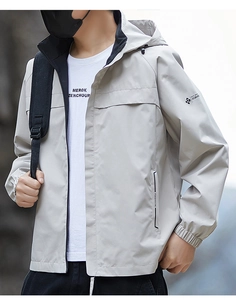 Detail of light grey outdoor jacket featuring fashion logo and windproof fabric texture