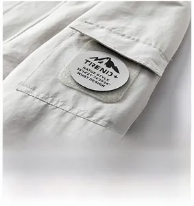 Detail of cargo pocket with mountain logo patch on durable windproof outdoor jacket