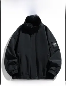 Detail of black outdoor jacket featuring windproof fabric and circular logo patch on the sleeve