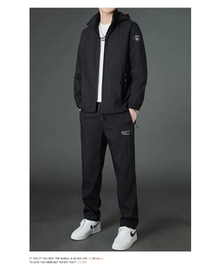Detail of premium black tracksuit with sleeve patch and fashion sport text on trousers
