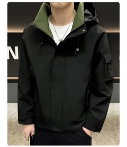 Détail d'une veste à capuche montrant le tissu noir, la doublure olive et une poche zippée