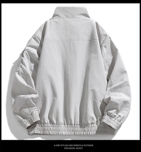 Back view of light grey windproof outdoor jacket featuring a standing collar and elastic cuffs