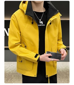 Detail of hooded jacket showing bright yellow fabric with black contrast zip and utility pockets
