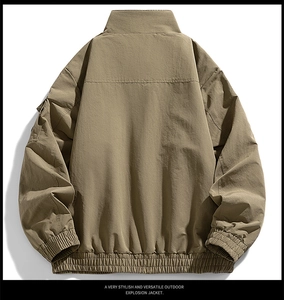 Back view of khaki outdoor functional jacket with utility arm pocket and ribbed cuffs