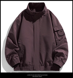 Close-up of windproof plum outdoor jacket with embroidered arm patch and zipper detail
