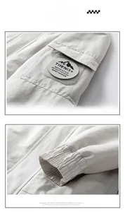 Detail of grey outdoor jacket featuring mountain logo patch on sleeve and elastic cuffs