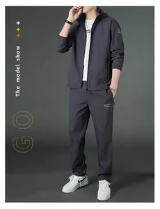 Detailed view of charcoal grey sports jacket and joggers set with stylish orange sleeve badge