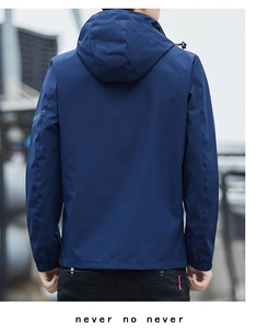 Rear view of deep blue hooded windbreaker jacket with elastic cuffs in outdoor setting