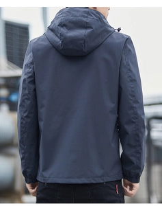 Detail of waterproof navy blue jacket showing hood drawstrings and elastic cuffs