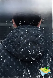 Dettaglio del tessuto impermeabile con gocce d'acqua su giacca a vento con monogramma