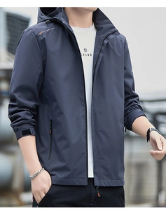 Dettaglio della giacca a vento blu navy con testo sportivo arancione e cappuccio