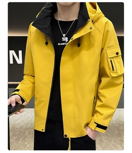 Détail d'une veste à capuche jaune avec poche utilitaire sur la manche et poignets à scratch