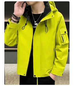 Détail de la poche cargo et fermeture éclair sur une veste à capuche vert fluo
