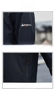 Dettaglio di una giacca outdoor nera con cerniera impermeabile e logo montagna sulla manica