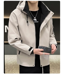 Détail d'une veste à capuche beige avec poignets réglables et matière coupe-vent robuste