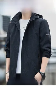 Detail of waterproof black jacket with dark leaf pattern and adjustable hood for men