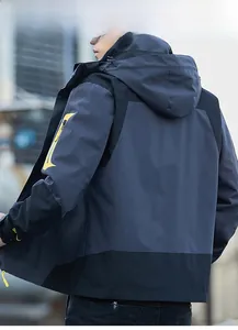 Detail of hooded outdoor jacket featuring navy and black panels with waterproof fabric