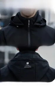 Detail of the brand zipper and detachable hood on this black windbreaker for men