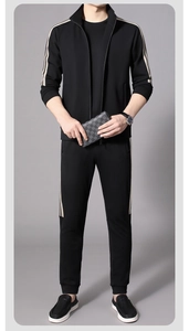 Detailed view of black elastic sports jacket and joggers with beige side stripes