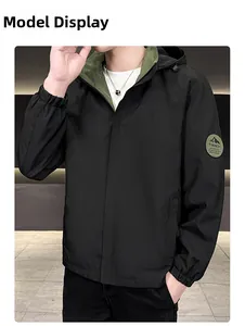 Detail of hooded jacket featuring contrasting olive lining and trendy arm patch on black fabric
