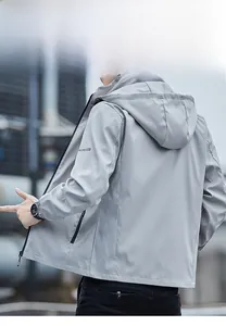 Detail of light grey men's hooded casual jacket featuring left sleeve logo and windproof fabric