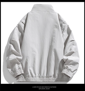 Rear view of a light gray windproof jacket with elastic cuffs and a stand collar design