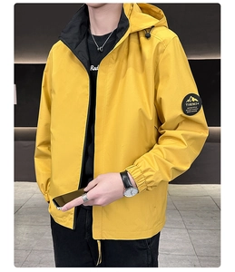 Detail of hooded jacket with yellow windproof fabric and contrast black lining accents