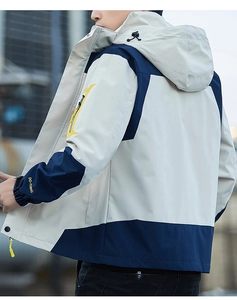 Detail of hooded windbreaker jacket with beige and navy color blocking and sleeve printing