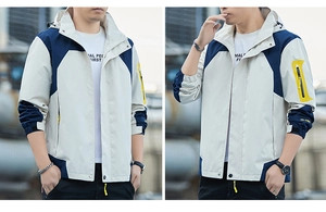 Detail of color-block windproof hooded jacket with adjustable velcro cuffs and zip pockets