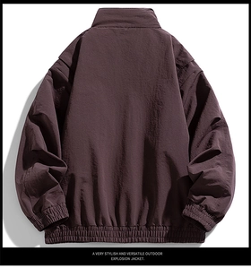Detail view of the layered back tailoring and elastic ribbed cuffs on the dark brown jacket