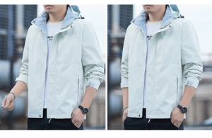 Detail of light grey outdoor hooded jacket featuring adjustable velcro cuffs and zip collar