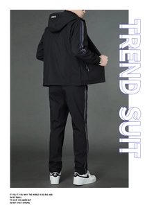 Vue arrière du survêtement de sport noir tendance avec bandes latérales à inscription mode