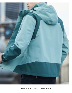 Detail of color-block hooded jacket showing windproof fabric and adjustable velcro cuffs