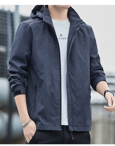 Detail of water-resistant windbreaker featuring subtle palm leaf pattern and zipper pockets