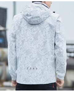 Detail of light grey windbreaker jacket featuring tropical leaf pattern and functional icons