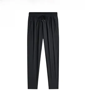 Détail du pantalon homme en soie glacée noire avec taille élastique, cordon et poches zippées