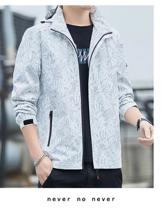 Detail of light gray windbreaker jacket featuring tropical leaf print and velcro cuffs