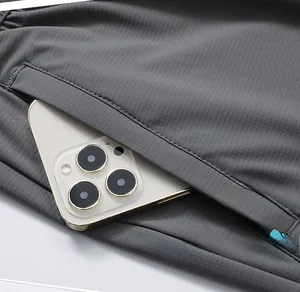 Vue détaillée du pantalon en soie glacée gris foncé avec des poches zippées pratiques
