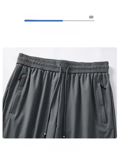 Détail du pantalon en soie glacée grise avec taille élastique, cordon et poches zippées