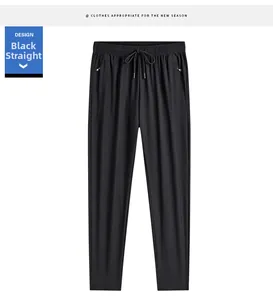 Detail of men's black ice silk pants showing elastic waist with drawstring and zipper pockets