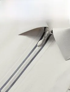 Detail view of seamless adhesive zipper and smooth fabric on men's polo shirt