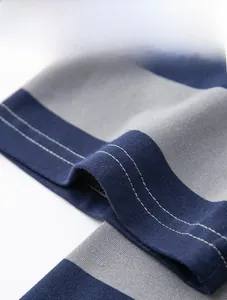 Gros plan de la manche du polo à rayures avec double couture précise et texture en maille