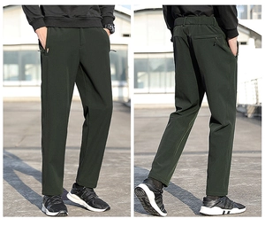 Vue en extérieur d'un pantalon de sport homme vert foncé avec poche zippée et taille élastique