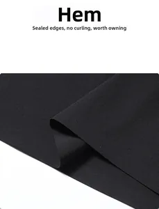 Détail macro de l'ourlet collé sur polo noir assurant une finition soignée sans roulement