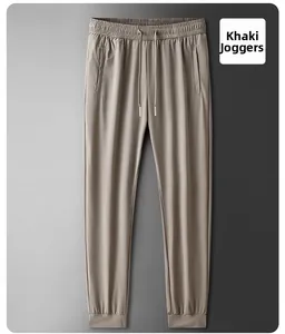 Detail of khaki ice silk jogger pants with elastic drawstring waist and zipper pockets