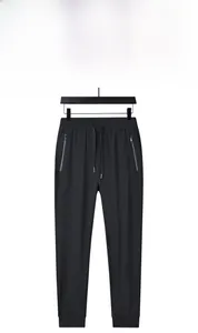 Detailed view of men's black ice silk joggers with drawstring waist and zipper pockets