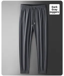 Detail of dark gray ice silk joggers featuring elastic drawstring waist and zip pockets