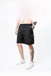 Detail of loose black cargo shorts with elastic drawstring waist and side pocket