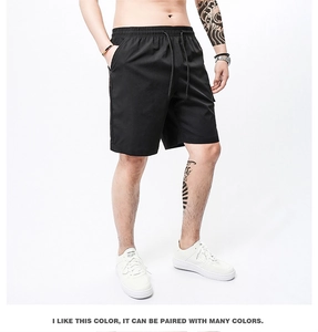 Detail of men's black quick-dry shorts featuring an adjustable elastic drawstring waistband